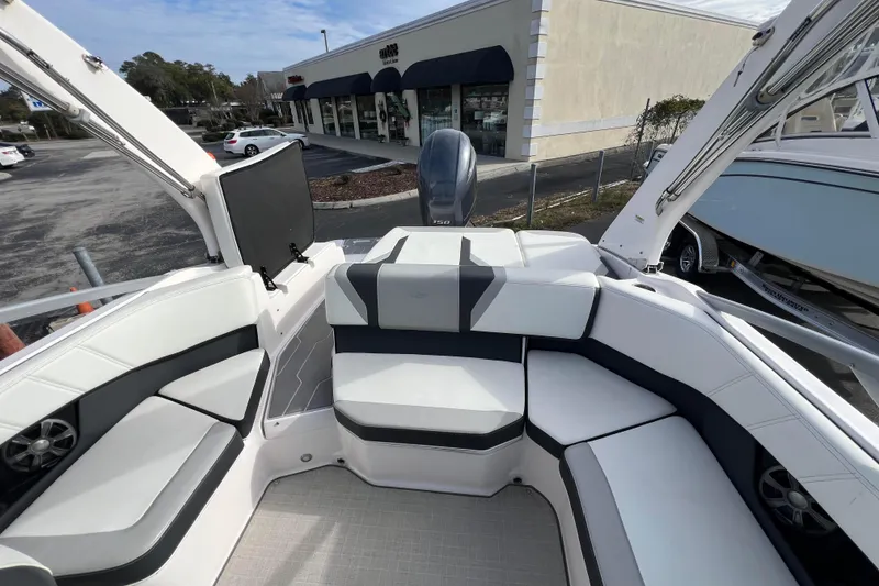 Slide: The Image of 2020 Regal 21 OBX boat interior with white and gray seating, parked outdoors. - 9