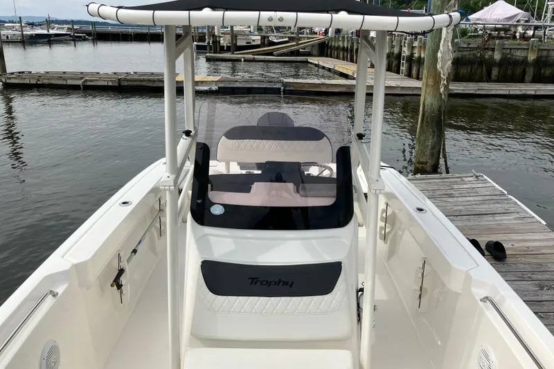 Slide: The Image of 2024 Trophy CC22 boat docked at marina, showcasing sleek design and spacious deck. - 5