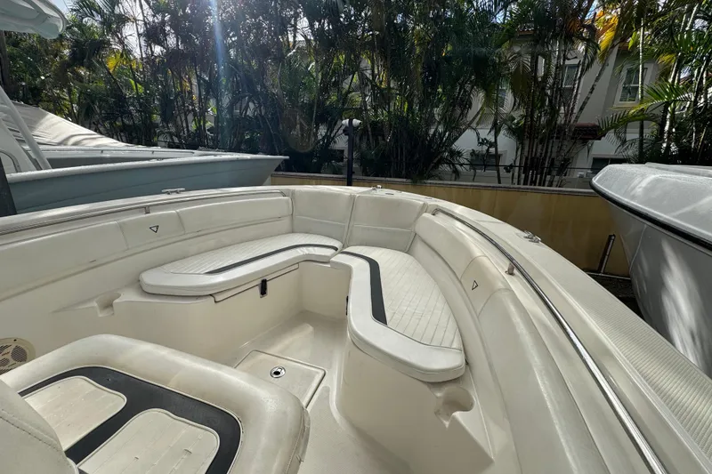 Slide: The Image of 2011 Sea Fox 226 Center Console boat interior with cushioned seating, surrounded by lush greenery. - 18