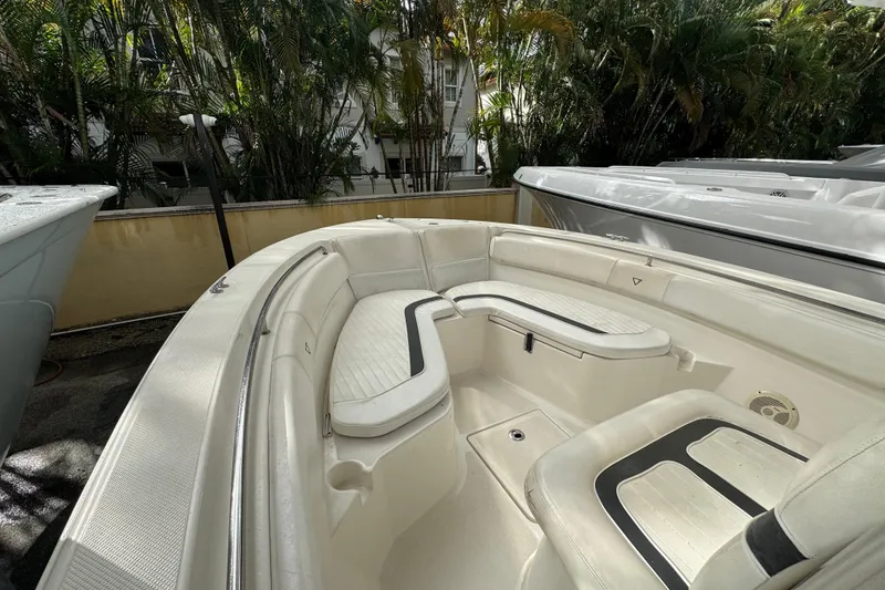 Slide: The Image of 2011 Sea Fox 226 Center Console boat interior with white seating and lush greenery background. - 19
