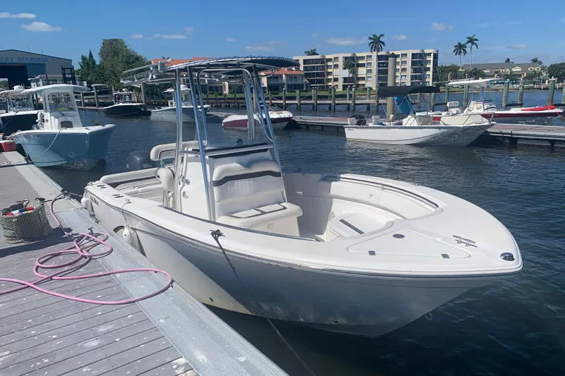 Slide: The Image of 2011 Sea Fox 226 Center Console boat docked at marina under clear blue sky. - 2