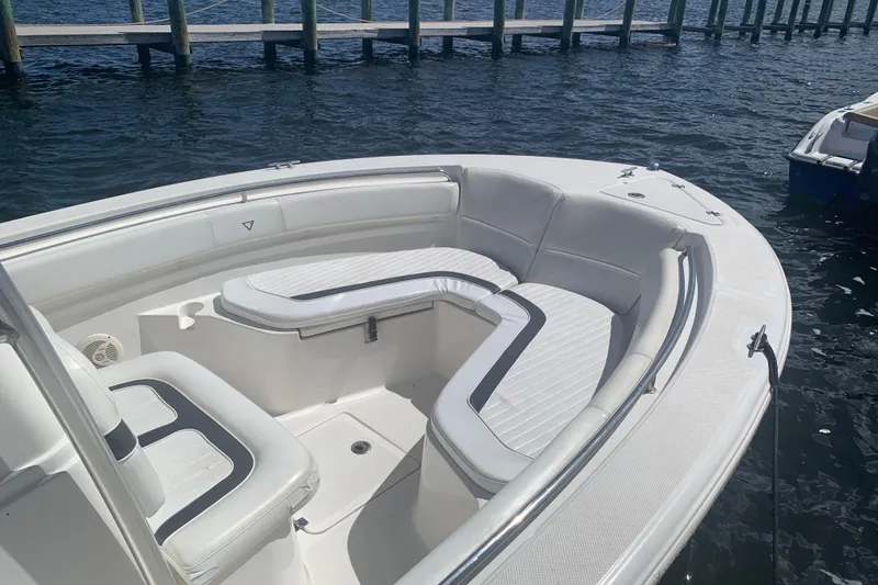 Slide: The Image of 2011 Sea Fox 226 Center Console boat with white seating, docked on calm water. - 5