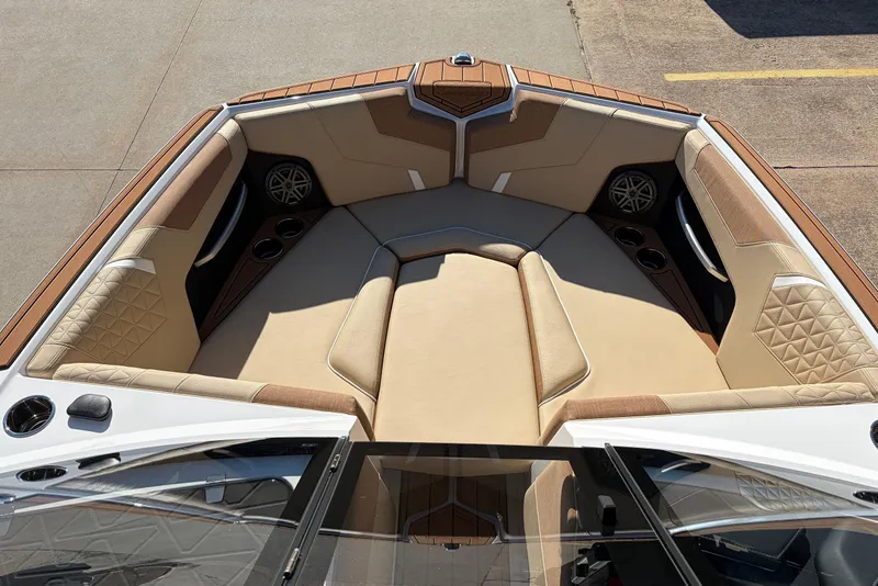 Slide: The Image of 2026 Nautique Super Air Nautique GS22 boat interior with beige seating and cup holders. - 12