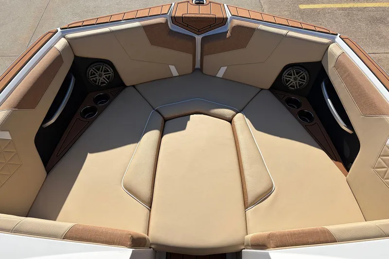 Slide: The Image of 2026 Nautique Super Air Nautique GS22 boat interior with beige seating and cup holders. - 13