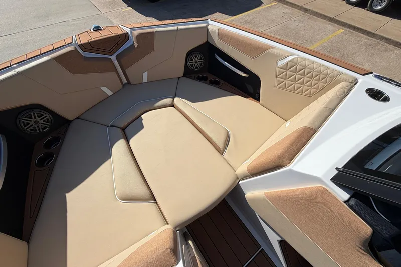 Slide: The Image of 2026 Nautique Super Air Nautique GS22 boat interior with beige seating and cup holders. - 15