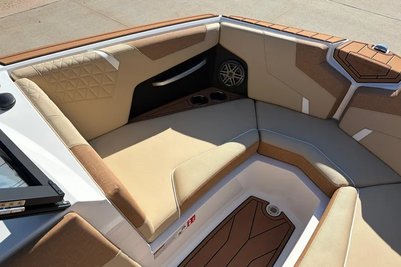 Slide: The Image of 2026 Nautique Super Air Nautique GS22 boat interior with tan seating and speaker system. - 17