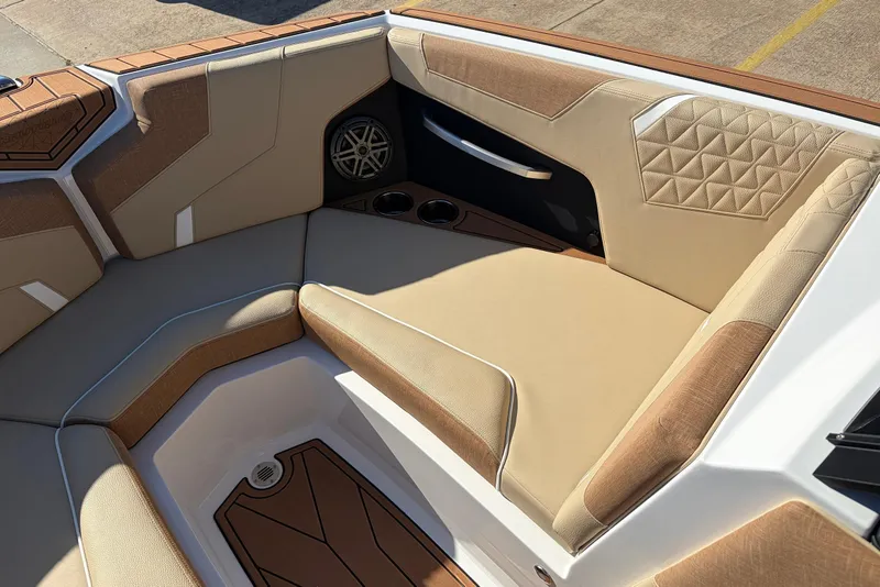 Slide: The Image of 2026 Nautique Super Air Nautique GS22 interior with tan upholstery and speaker detail. - 18