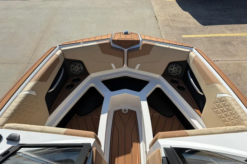Slide: The Image of 2026 Nautique Super Air Nautique GS22 boat interior with tan seating and cup holders. - 19