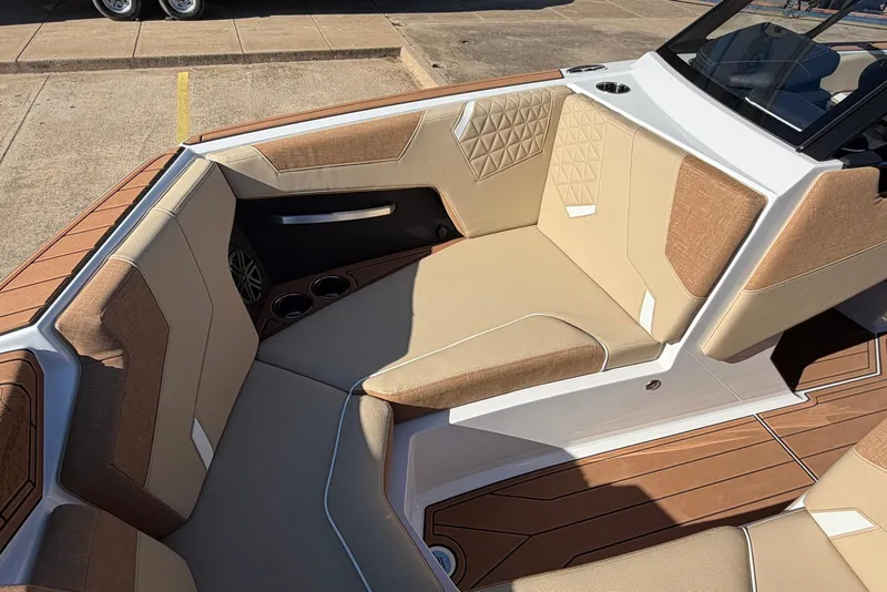 Slide: The Image of 2026 Nautique Super Air Nautique GS22 interior with tan and brown seating, cup holders, and modern design. - 23