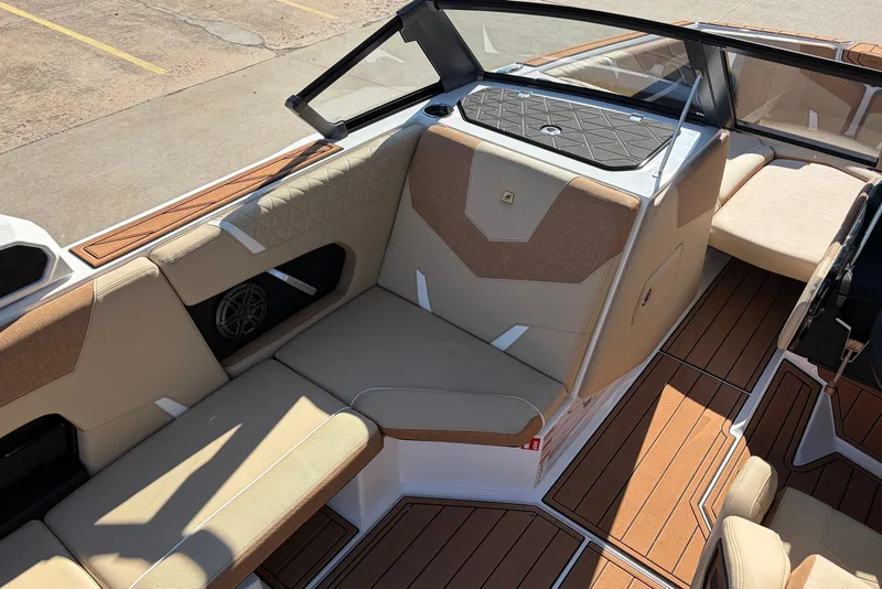 Slide: The Image of 2026 Nautique Super Air Nautique GS22 interior with tan seating and wood accents. - 30