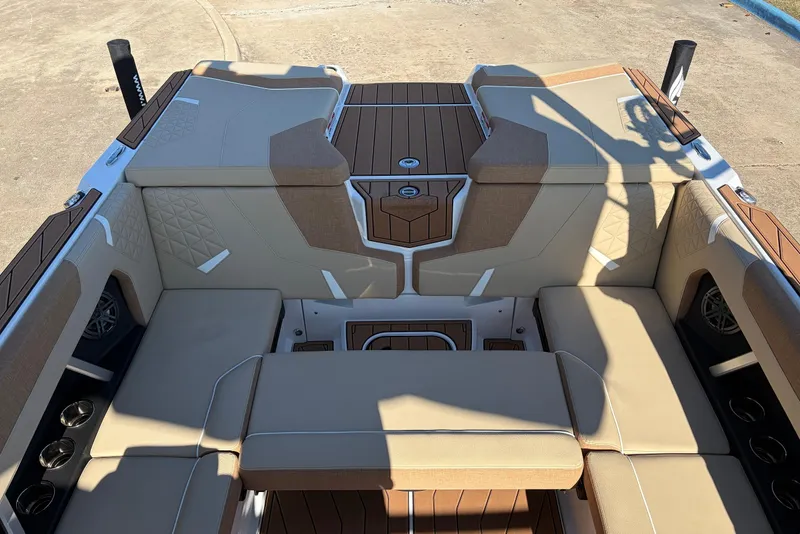 Slide: The Image of 2026 Nautique Super Air Nautique GS22 interior with tan upholstery and wood accents. - 40