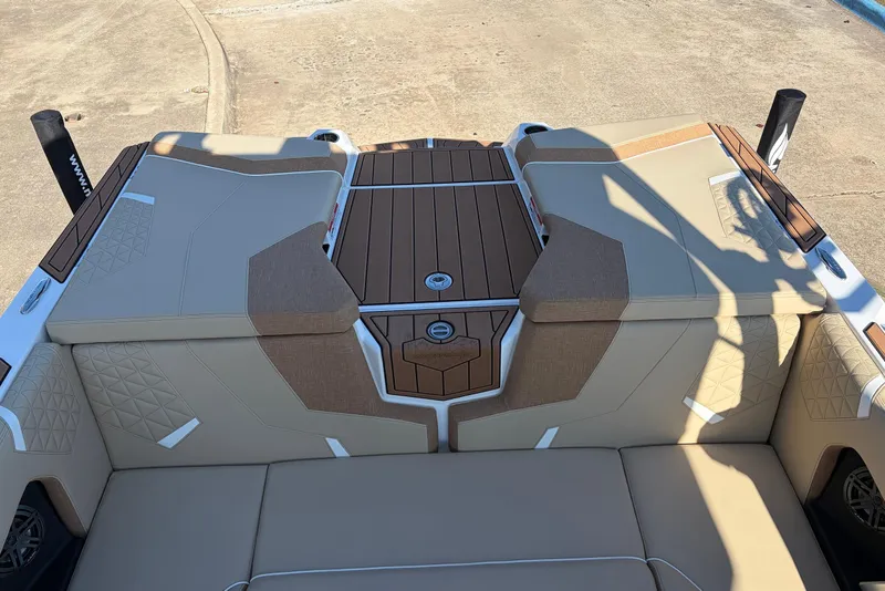 Slide: The Image of 2026 Nautique Super Air Nautique GS22 boat interior with tan upholstery and wood accents. - 54