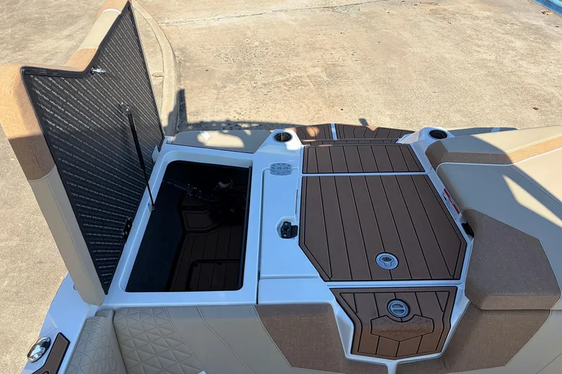 Slide: The Image of 2026 Nautique Super Air Nautique GS22 boat storage compartment with open hatch. - 55