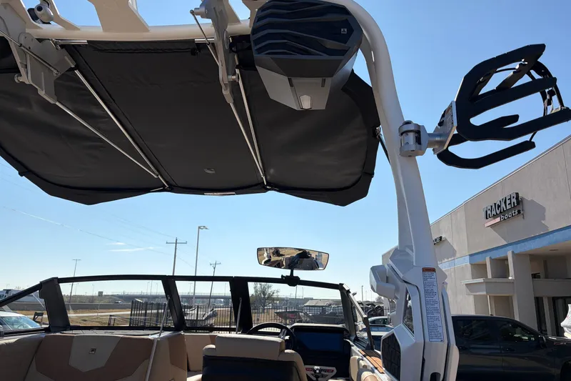 Slide: The Image of 2026 Nautique Super Air Nautique GS22 boat interior with tower speakers and bimini top. - 64