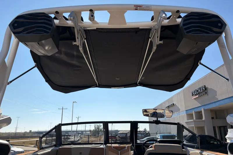 Slide: The Image of 2026 Nautique Super Air Nautique GS22 boat with speakers and canopy, dealership background. - 65