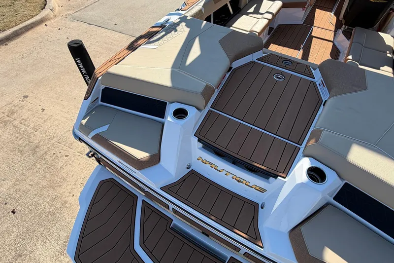 Slide: The Image of 2026 Nautique Super Air Nautique GS22 boat interior with sleek seating and deck design. - 66