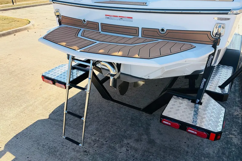 Slide: The Image of 2026 Nautique Super Air Nautique GS22 boat rear view with swim platform and ladder. - 8