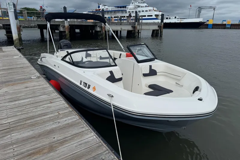 The Image of 2024 Bayliner VR6 Bowrider OB docked at a marina, featuring sleek design and spacious seating. - 1