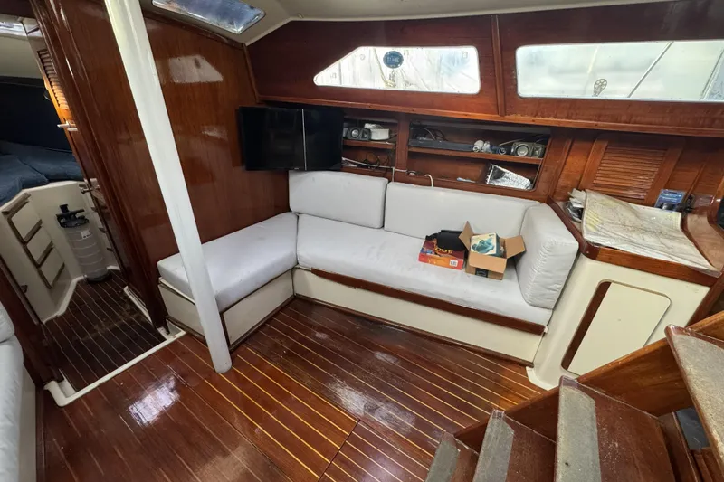 Slide: The Image of 1987 Irwin 38 yacht interior with wooden finish, white seating, and navigation equipment. - 16