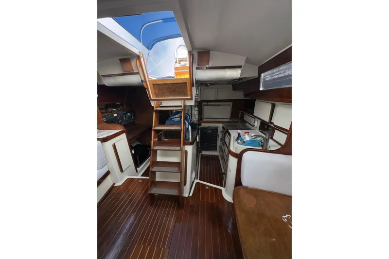 Slide: The Image of Interior of 1987 Irwin 38 sailboat with wooden flooring and compact kitchen area. - 18
