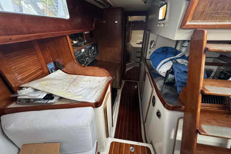 Slide: The Image of Interior of a 1987 Irwin 38 sailboat with wooden finishes and navigation maps. - 21