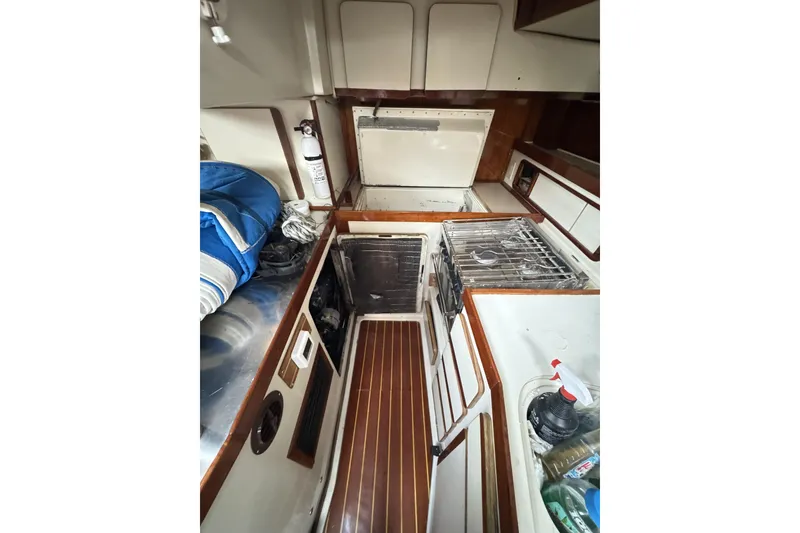 Slide: The Image of Interior of 1987 Irwin 38 sailboat galley with stove, storage, and wooden flooring. - 23