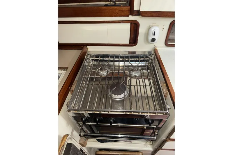 Slide: The Image of 1987 Irwin 38 yacht kitchen with stainless steel stove and wooden cabinetry. - 25