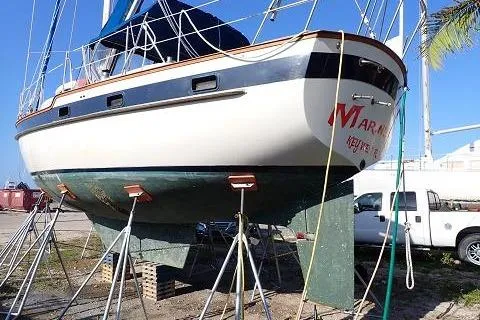 Slide: The Image of 1987 Irwin 38 sailboat on stands, ready for maintenance in a sunny boatyard. - 3