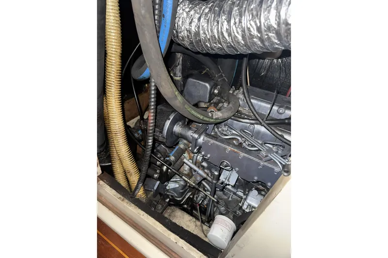 Slide: The Image of Engine compartment of a 1987 Irwin 38 sailboat, showing hoses and mechanical components. - 32