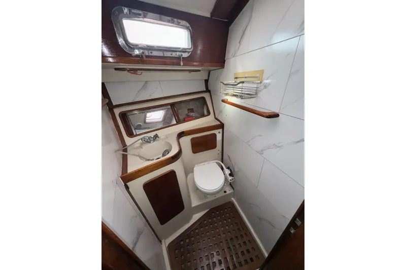 Slide: The Image of 1987 Irwin 38 yacht bathroom with sink, toilet, and wooden accents. - 37