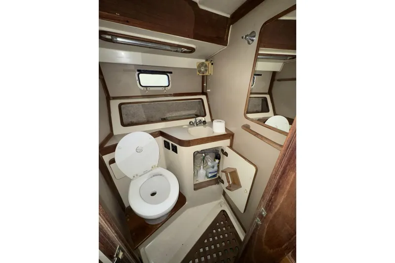 Slide: The Image of 1987 Irwin 38 yacht bathroom with toilet, sink, mirror, and storage. - 45