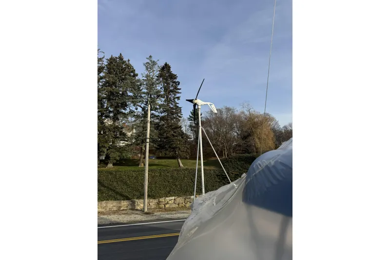 Slide: The Image of Wind turbine on an Irwin 38 sailboat, 1987 model, near a tree-lined road. - 49