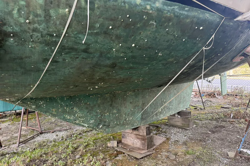 Slide: The Image of 1987 Irwin 38 sailboat hull with marine growth, supported on blocks. - 6
