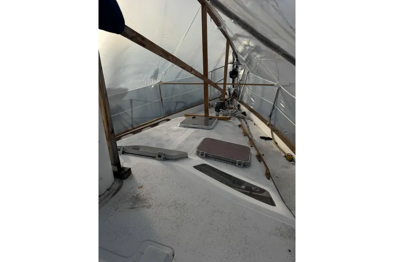Slide: The Image of 1987 Irwin 38 sailboat deck under protective cover, showing hatches and rigging. - 8
