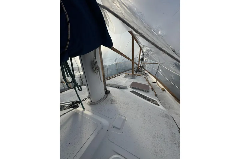 Slide: The Image of 1987 Irwin 38 sailboat deck under protective cover, featuring mast and rigging. - 9