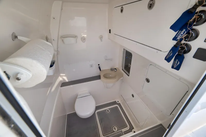Slide: The Image of 2022 Invincible 39 Open Fisherman boat bathroom with toilet, sink, and storage compartments. - 27