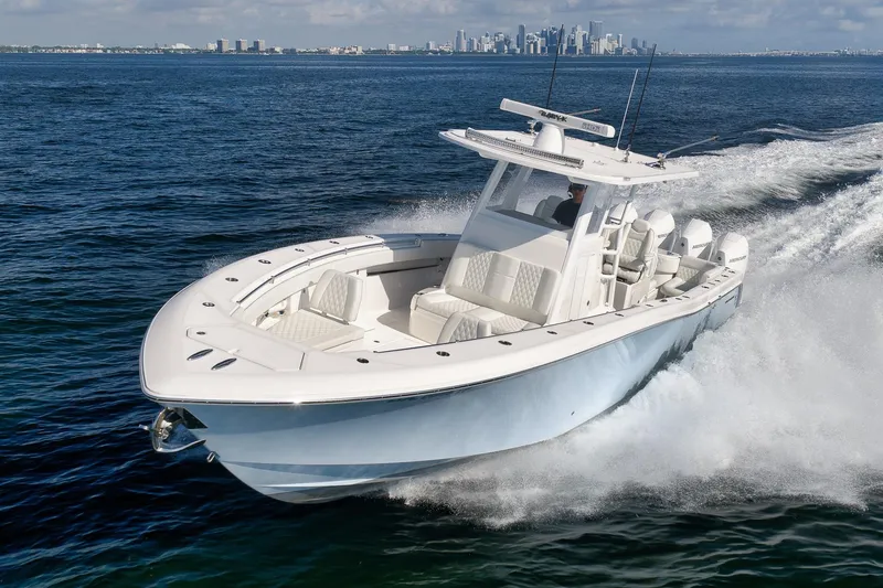 Slide: The Image of 2022 Invincible 39 Open Fisherman boat cruising on open water with city skyline backdrop. - 5