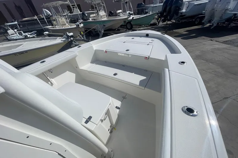 Slide: The Image of 2026 Pathfinder 2400 Open boat interior with seating and storage, docked among other boats. - 10