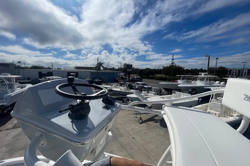 Slide: The Image of 2026 Pathfinder 2400 Open boat steering console with multiple boats in a dealership lot. - 12