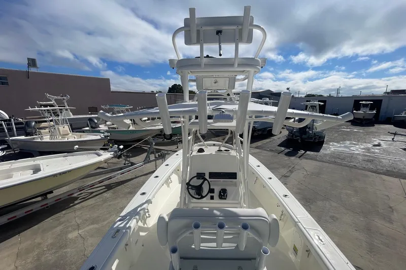 Slide: The Image of 2026 Pathfinder 2400 Open boat, center console view, docked with other boats under cloudy sky. - 14