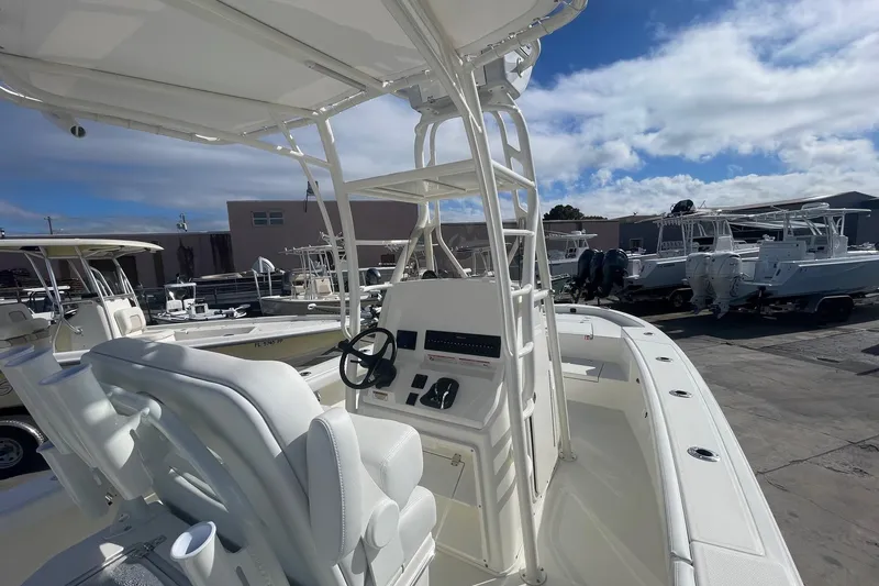 Slide: The Image of 2026 Pathfinder 2400 Open boat interior with steering console, docked under blue sky. - 5