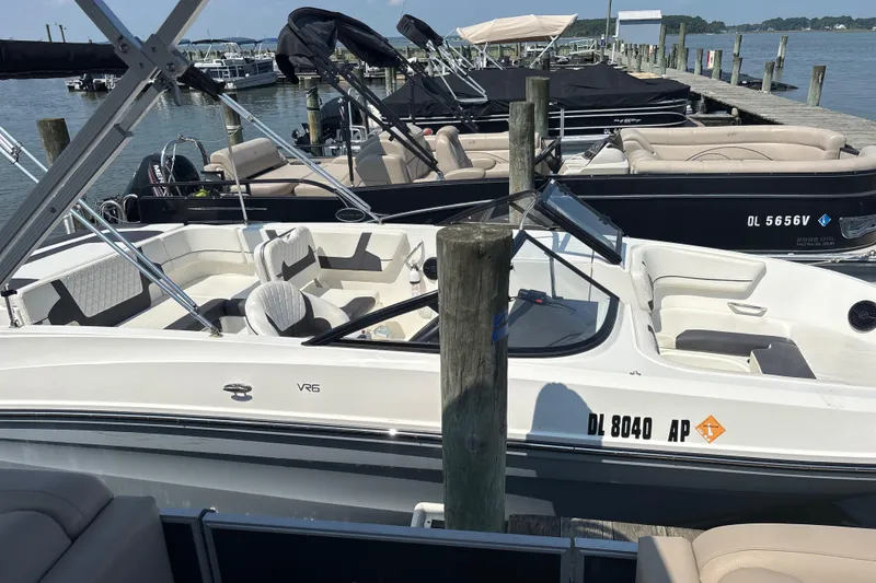 Slide: The Image of 2024 Bayliner VR6 Bowrider OB docked at a marina, showcasing sleek design and spacious seating. - 4