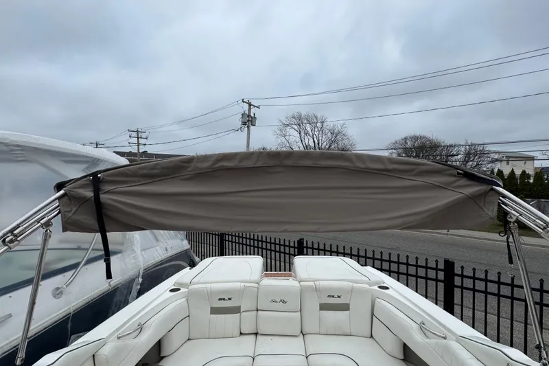 Slide: The Image of 2007 Sea Ray 270 SLX boat with bimini top, white seating, and overcast sky. - 11
