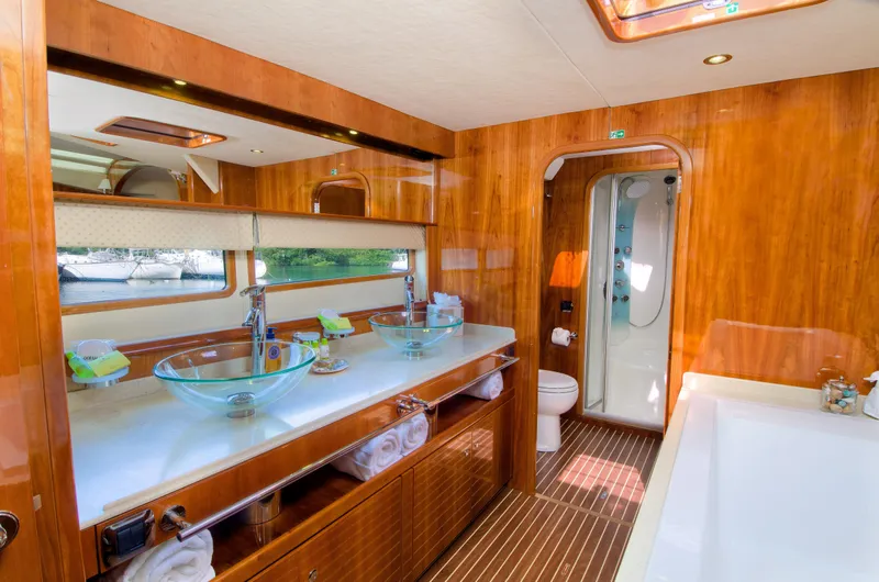 Slide: The Image of Luxurious bathroom on a 2010 Privilege 745 yacht with glass sinks and wooden finishes. - 36