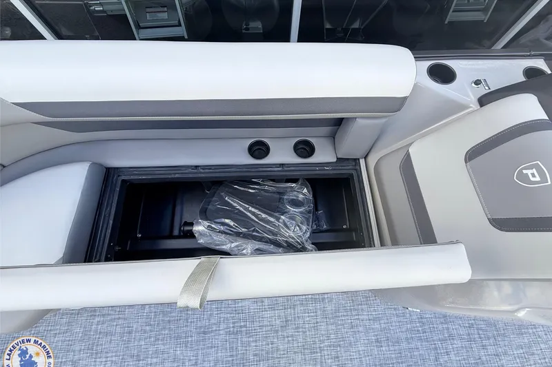 Slide: The Image of 2026 Premier 220 Sunscape RF boat interior with storage compartment and cup holders. - 6