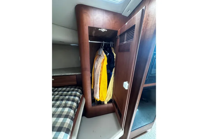 Slide: The Image of 2003 Rampage 38 Express cabin with open closet and hanging jackets. - 12