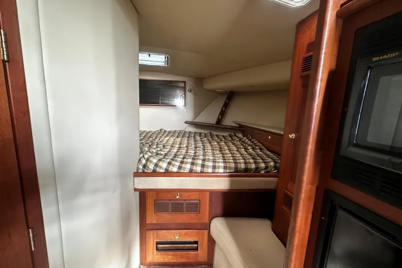 Slide: The Image of 2003 Rampage 38 Express cabin interior with bed, wood cabinetry, and microwave. - 13