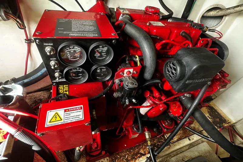 Slide: The Image of Engine compartment of a 2003 Rampage 38 Express boat, featuring red mechanical components. - 15