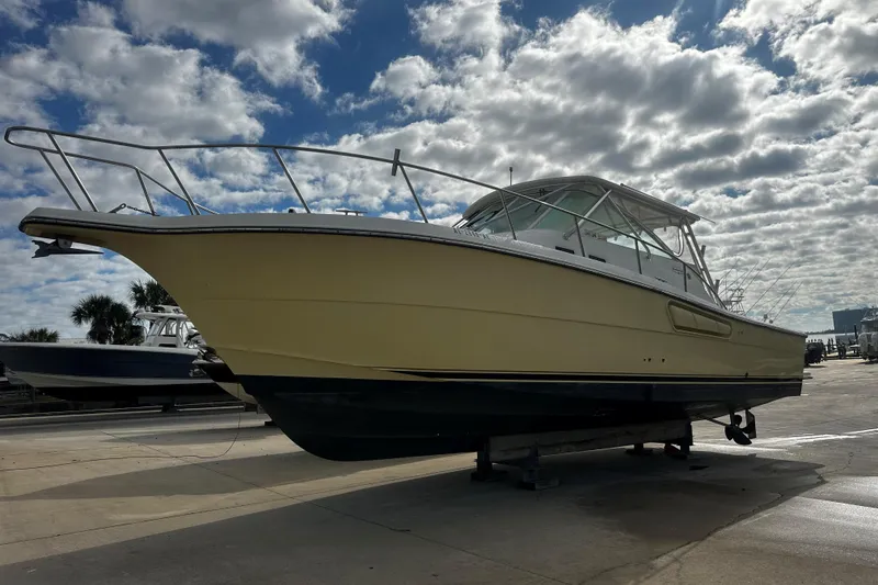 Slide: The Image of 2003 Rampage 38 Express boat on dry dock under cloudy sky. - 2