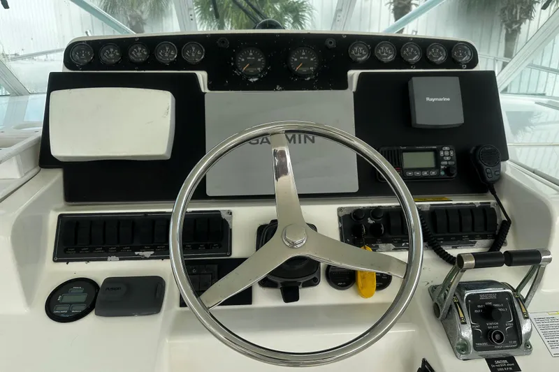 Slide: The Image of 2003 Rampage 38 Express helm with steering wheel, gauges, and navigation equipment. - 23